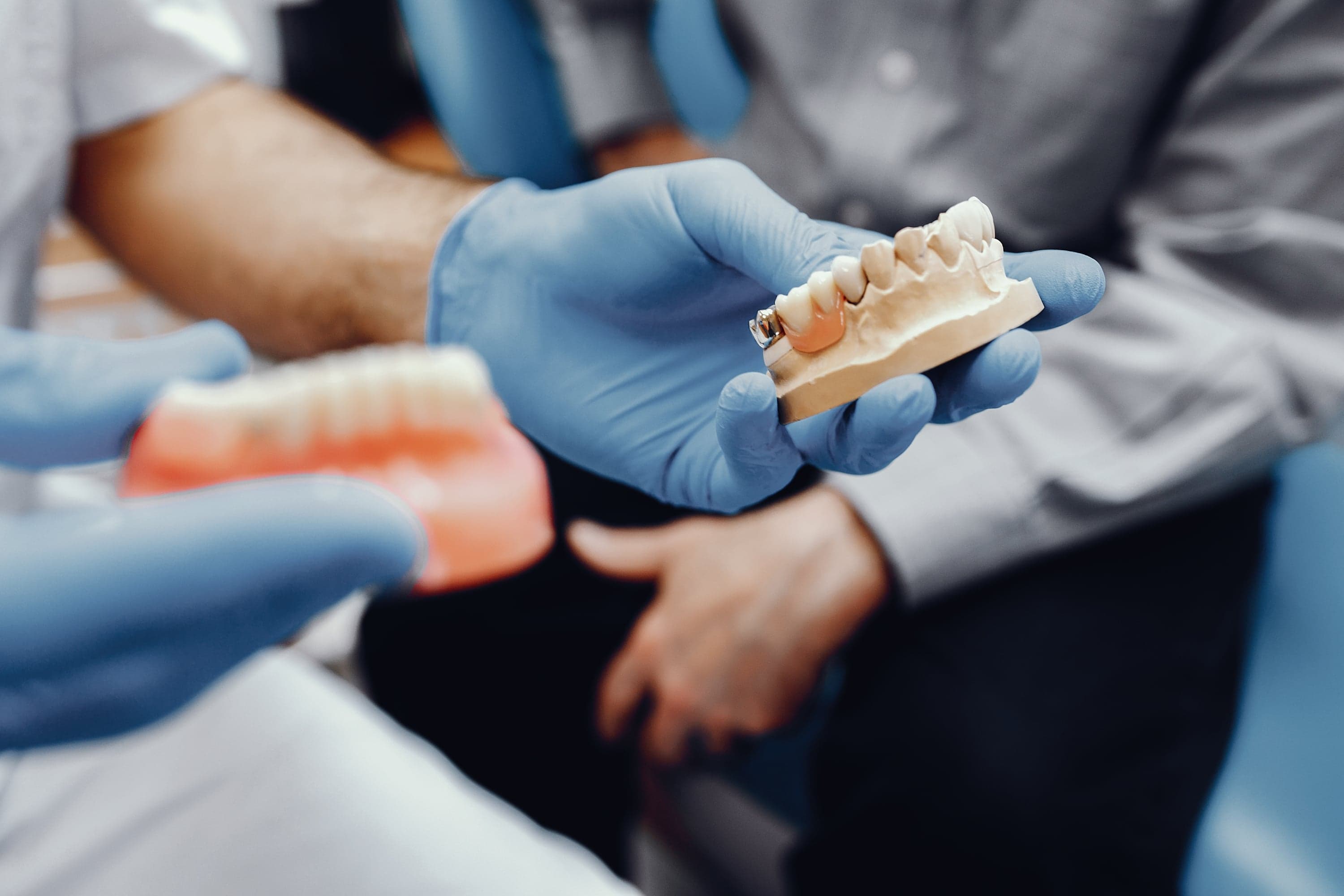 Dental professional examining a ceramic crown at Joyner Family Dental