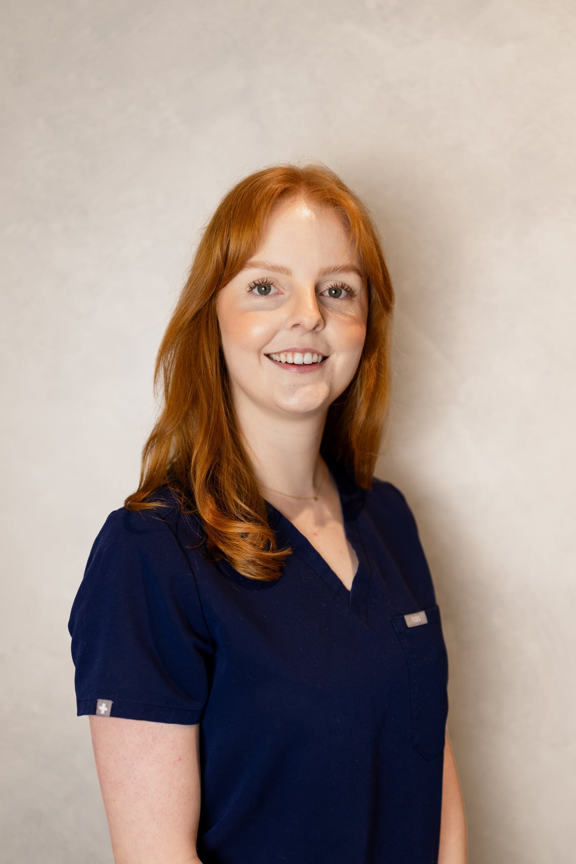 Dr Lissy, Associate Dentist at Joyner Family Dental, smiling in navy scrubs
