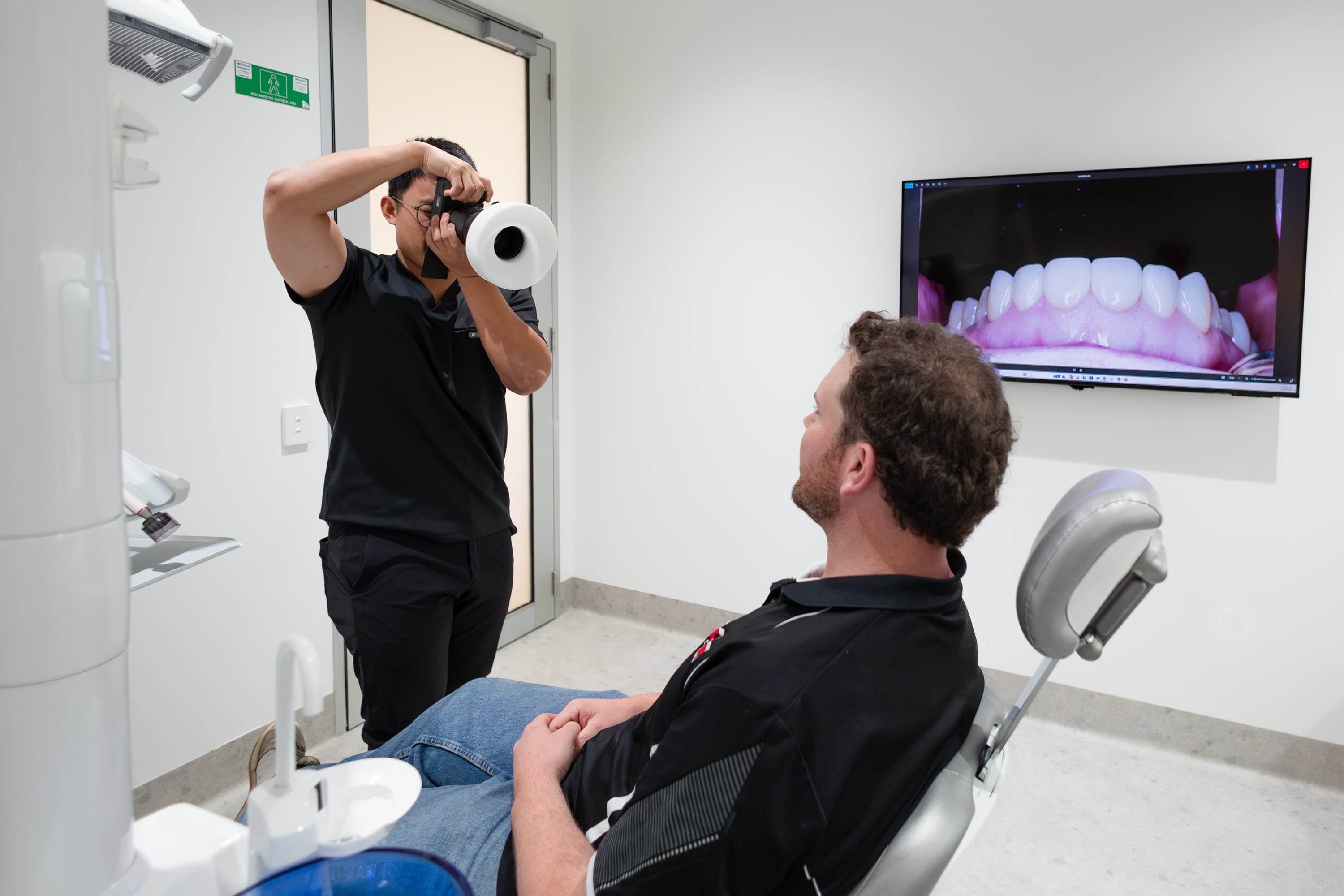 Dentist and patients reviewing denture options in a consultation room