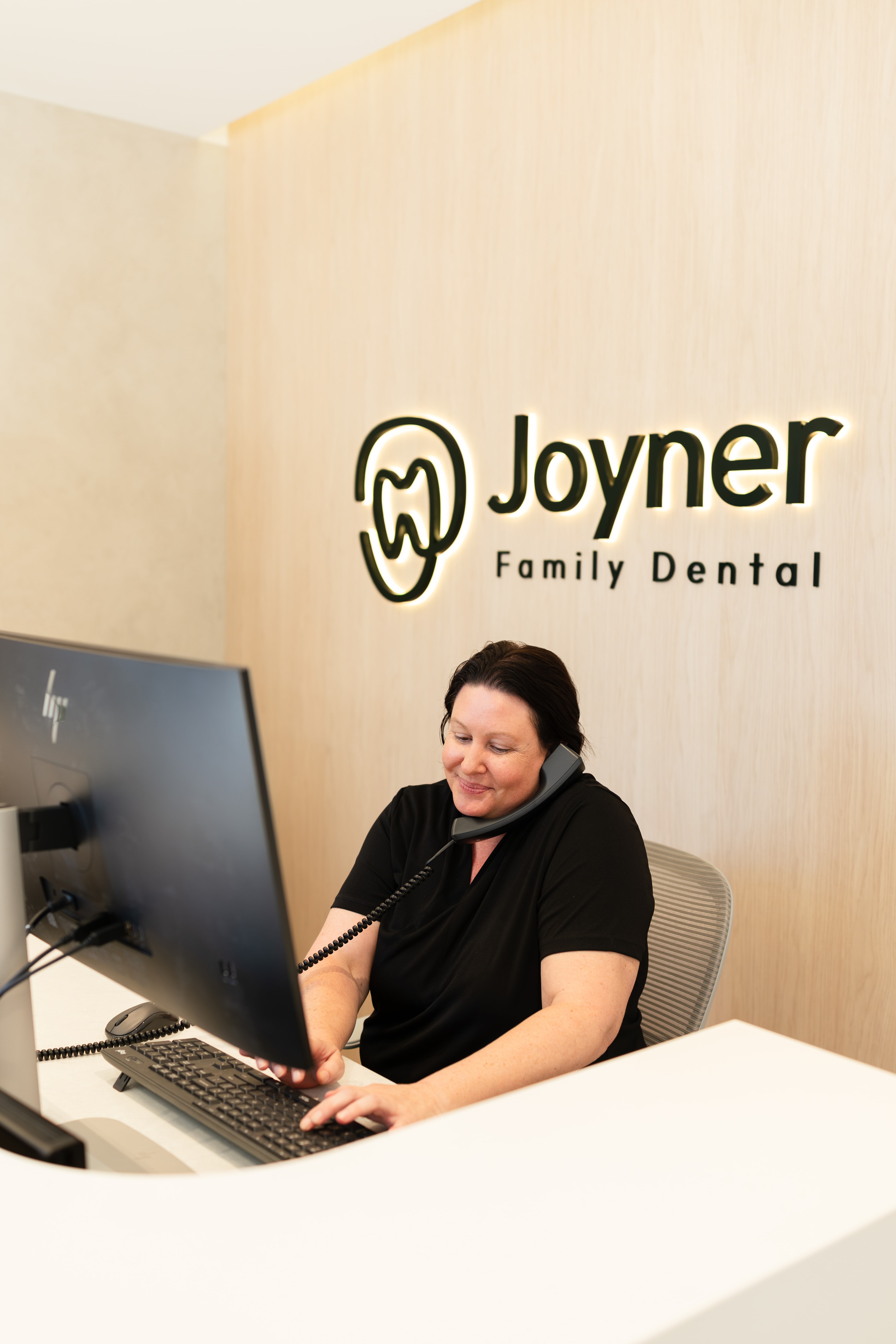 Receptionist answering an emergency dental call at Joyner Family Dental