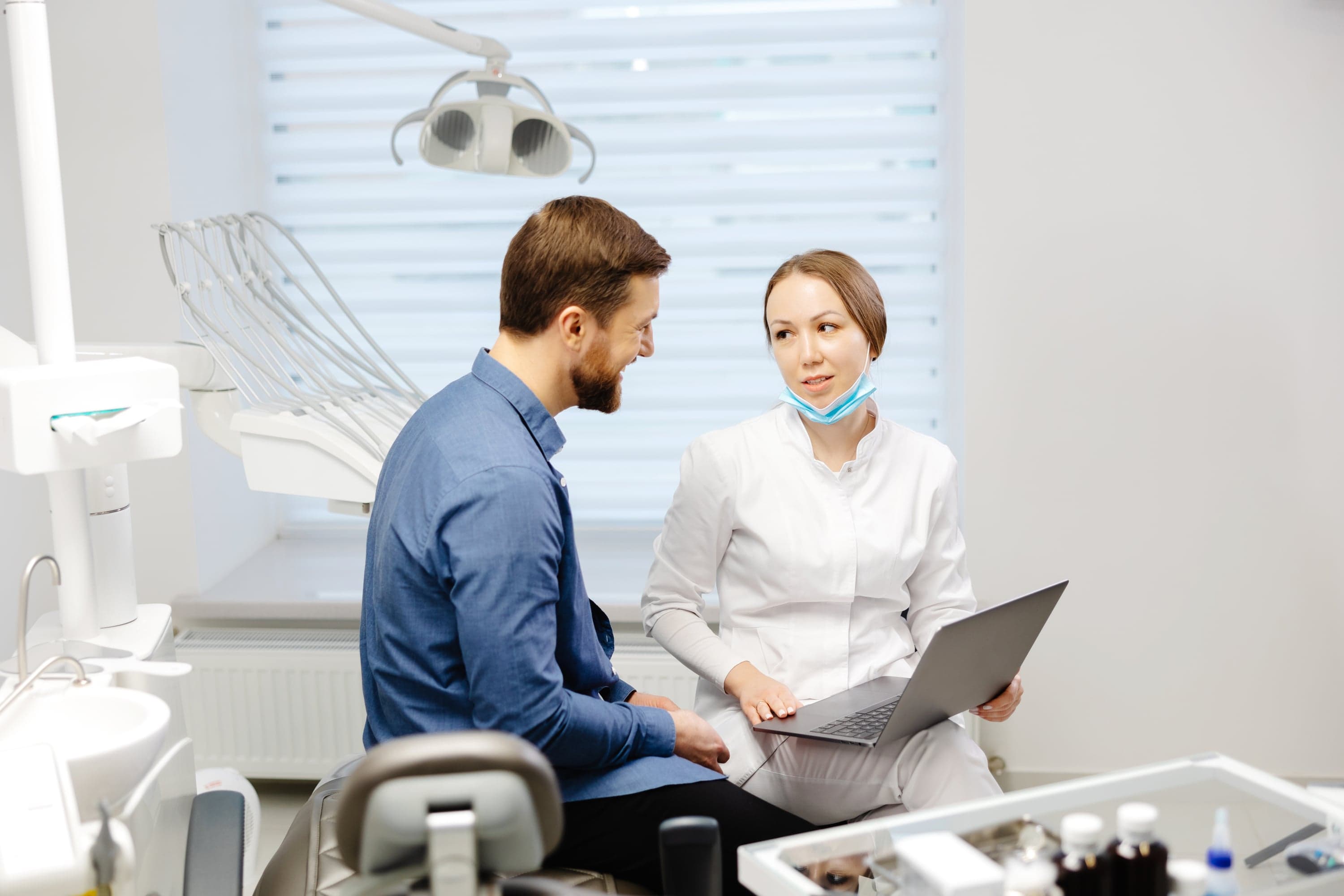 Dentist discussing a written treatment plan with a patient at the consultation desk