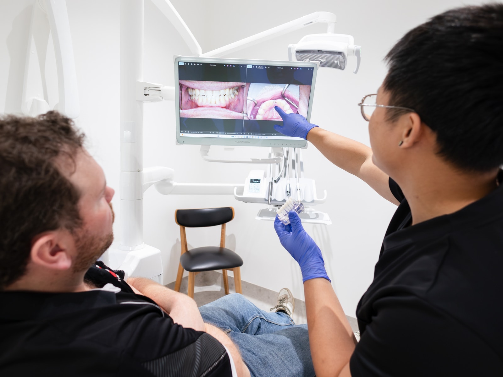 Patient reviewing clear aligner goals in a hand mirror