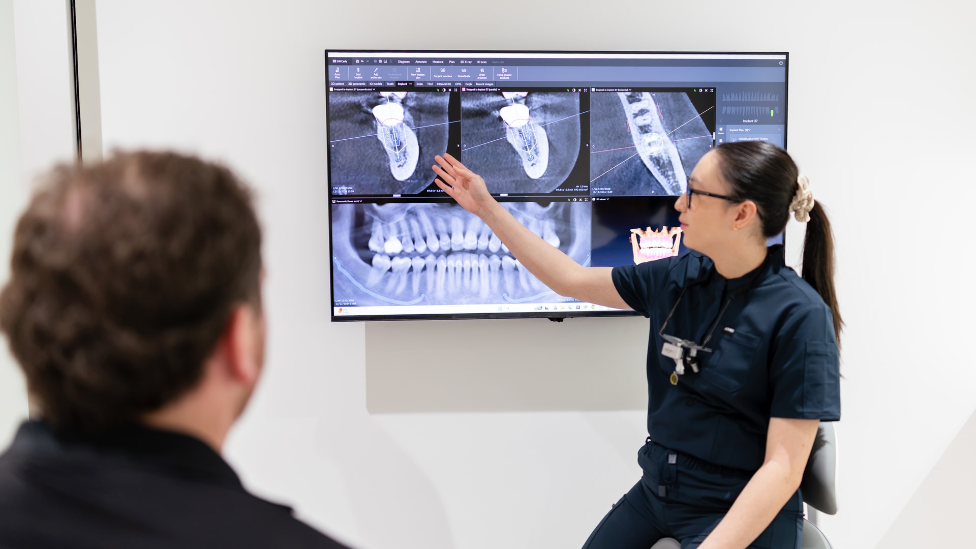 Dentist reviewing panoramic x-ray showing wisdom teeth at Joyner Family Dental
